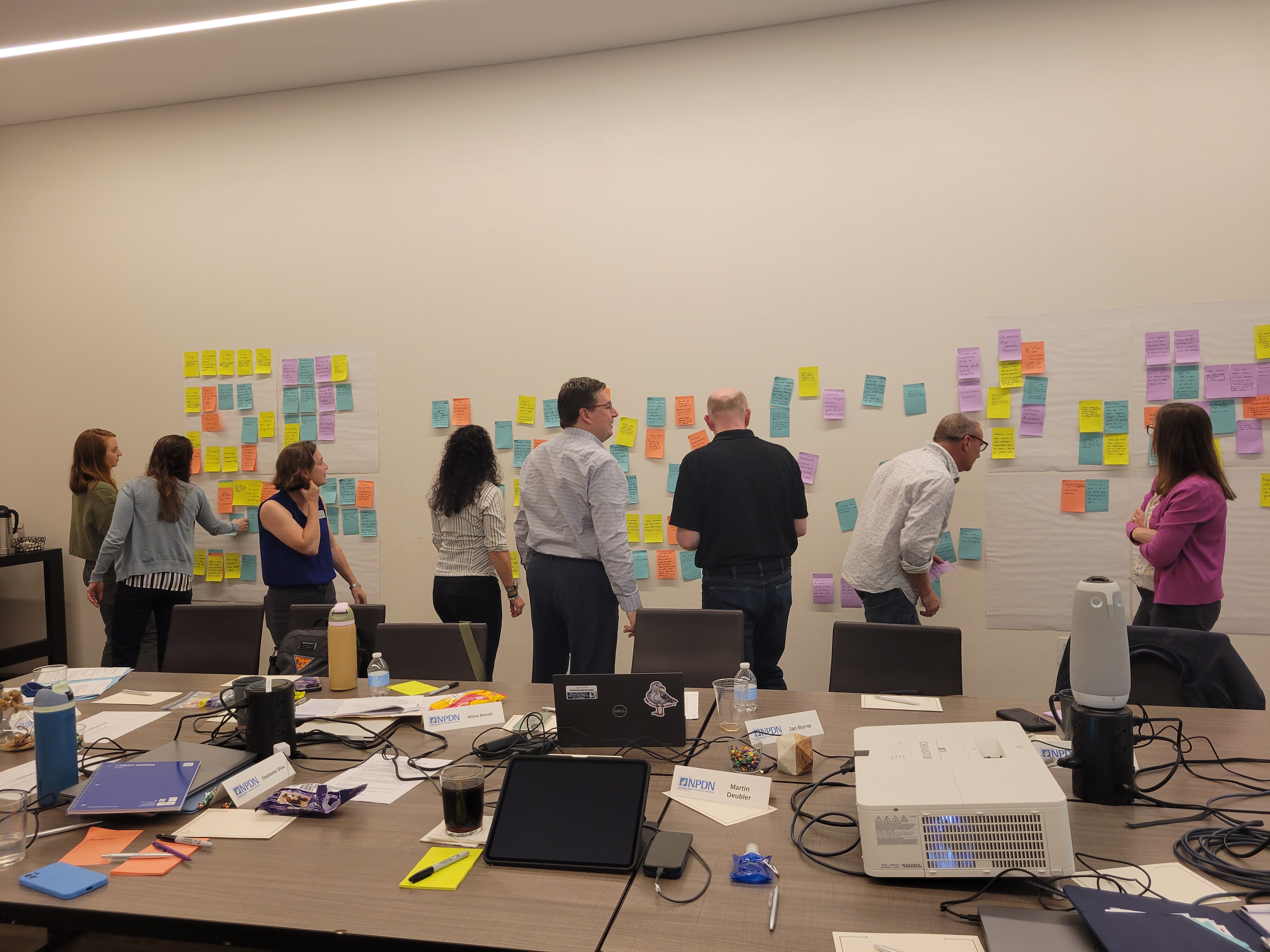 A group of people brainstorming ideas using sticky notes on a wall.