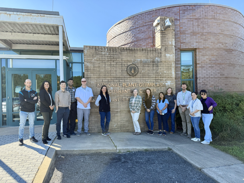 A small group of people standing in front of a large brick marquee.