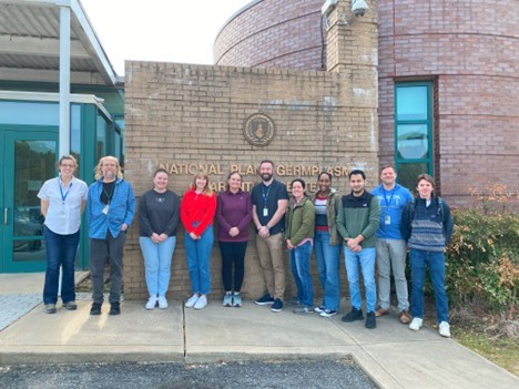A group of people standing in front of a large brick marquee