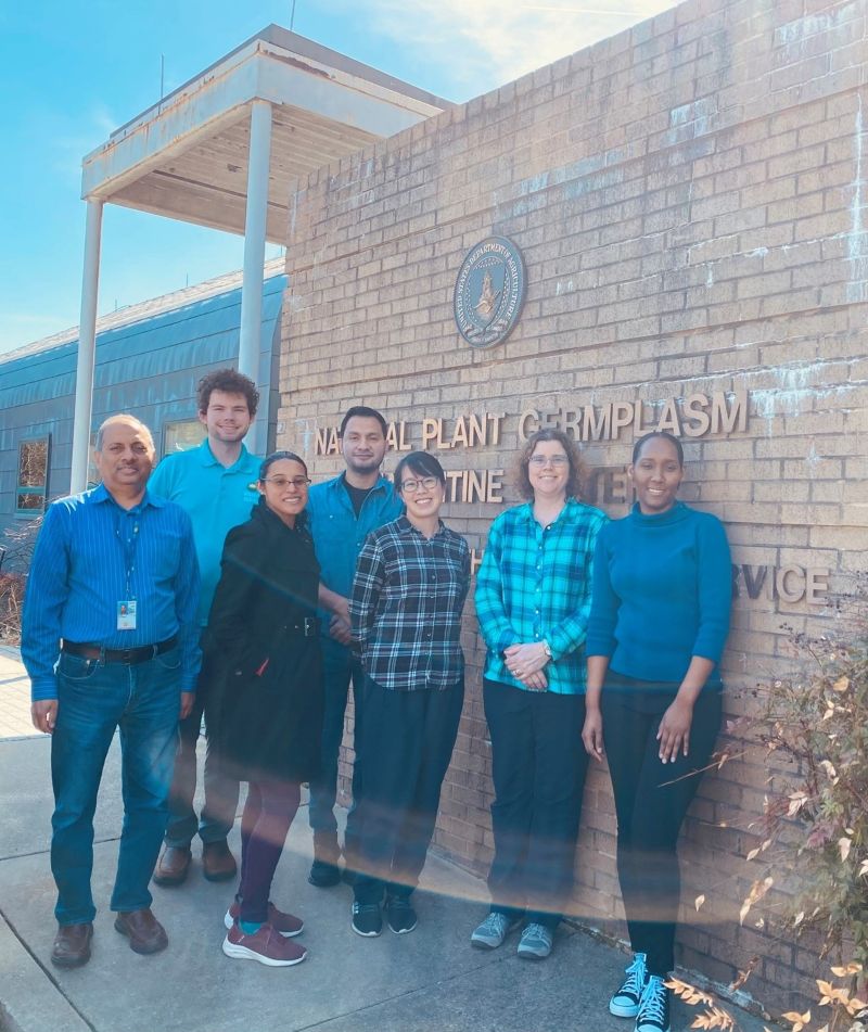 A group of people standing in front of a large brick marquee