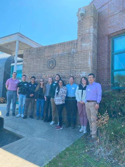 A group of people standing in front of a large brick marquee