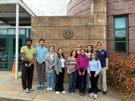 A group photo in front of a brick sign